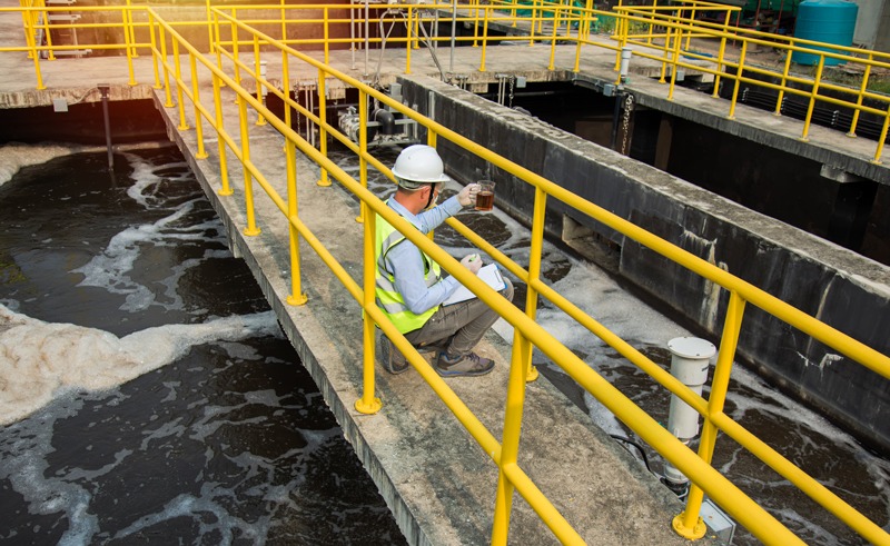Water Treatment Specialist takes sample of system